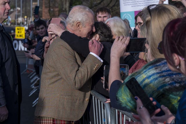 A woman hugs the King