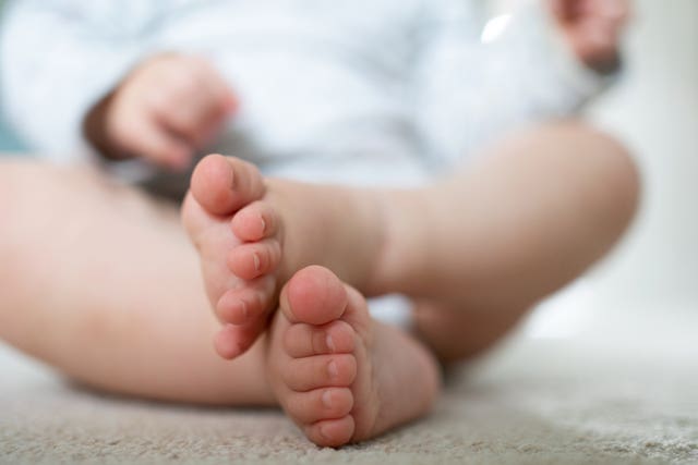 The feet and legs of a young child