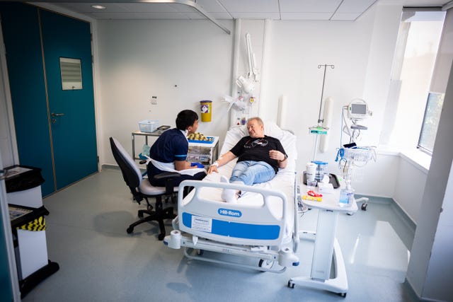 Patient Janusz Racz receives an injection of a BioNTech mRNA cancer immunotherapy for non-small cell lung cancer from Keenjee Nama, senior research nurse at the University College London Hospital clinical research facility in central London