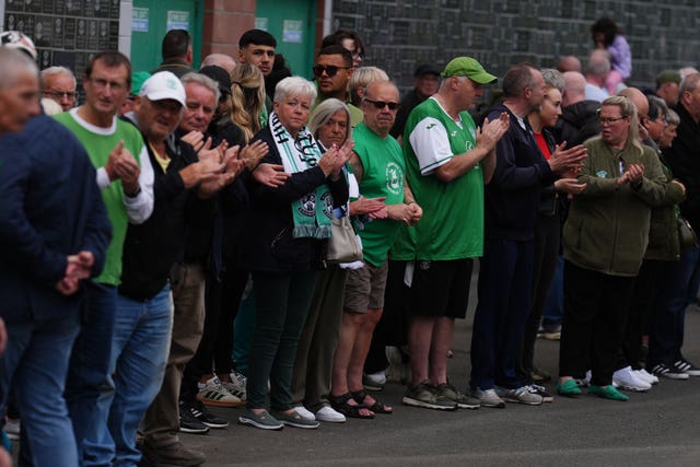 People wearing Hibs colours lining a street