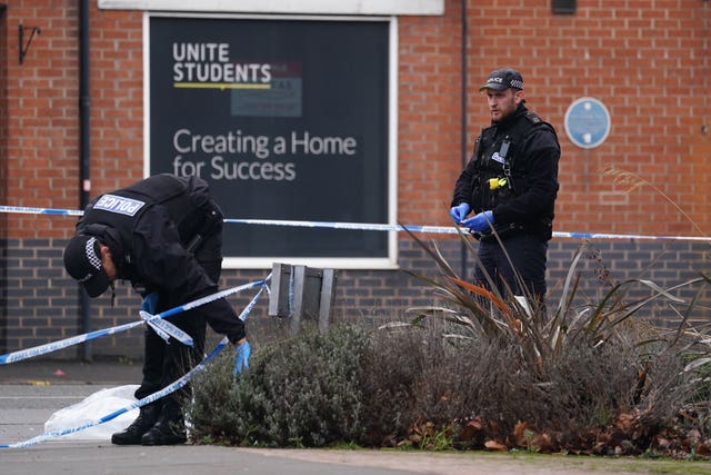 Police officers search shrubs