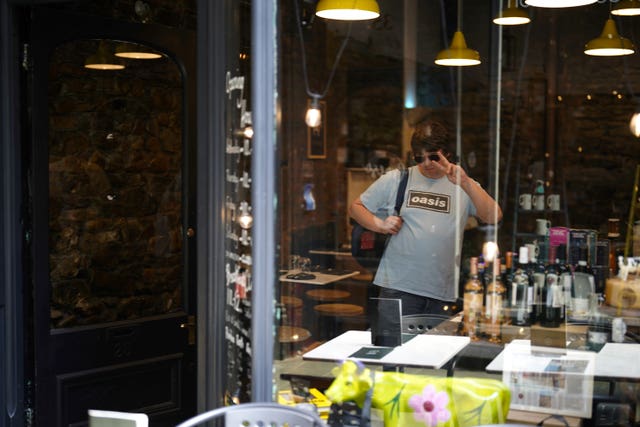 An Oasis fan strikes a pose in a shop window in Cardiff