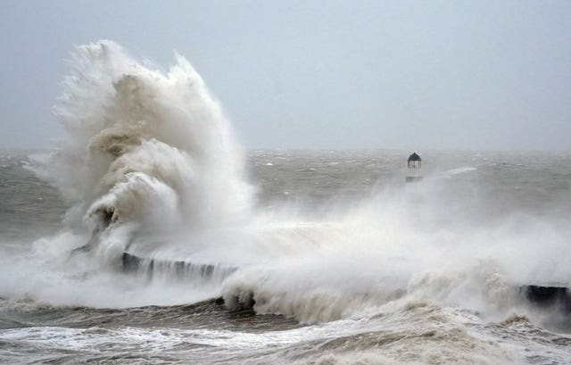 Waves crash against the lighthouse in Seaham Harbour, County Durham 