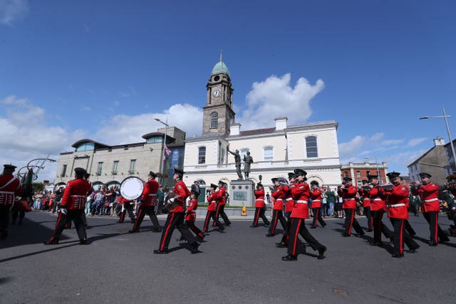 A band march past the Ulster Defence Force memorial in Lisburn