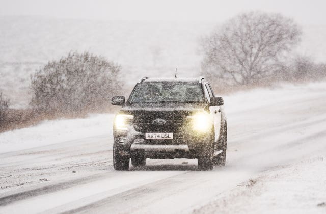 A car navigates snowy conditions on the A169 near Saltergate in North York Moors National Park