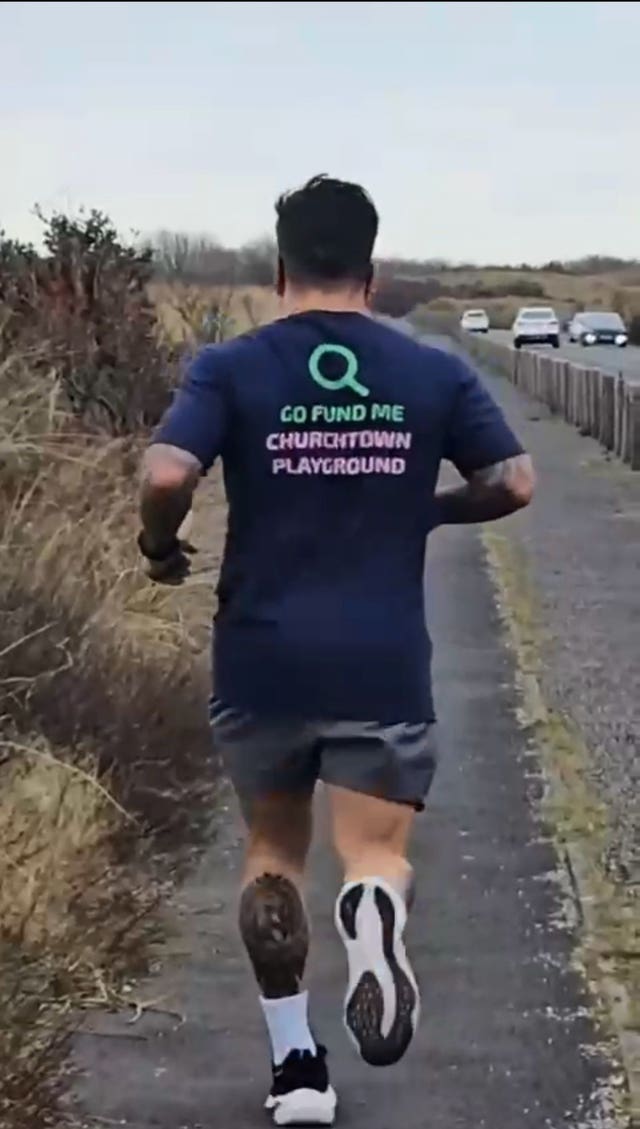 Sergio Aguiar from behind, running while wearing a T-shirt which advertises the playground GoFundMe