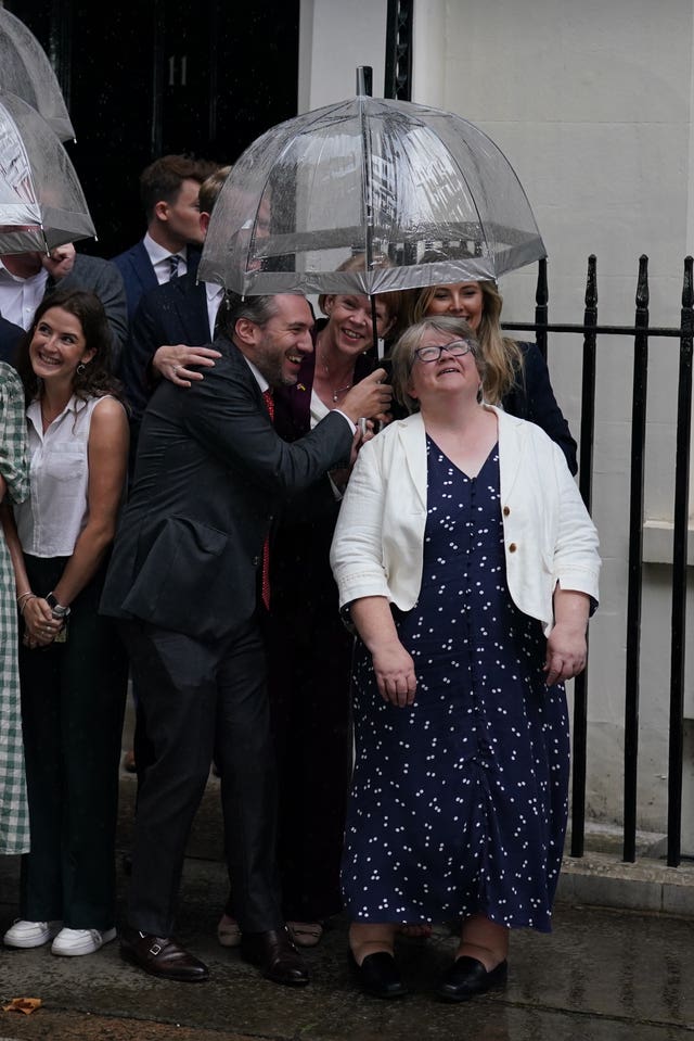 Therese Coffey shelters from the rain as she awaits the arrival of new Prime Minister Liz Truss in Downing Street, London