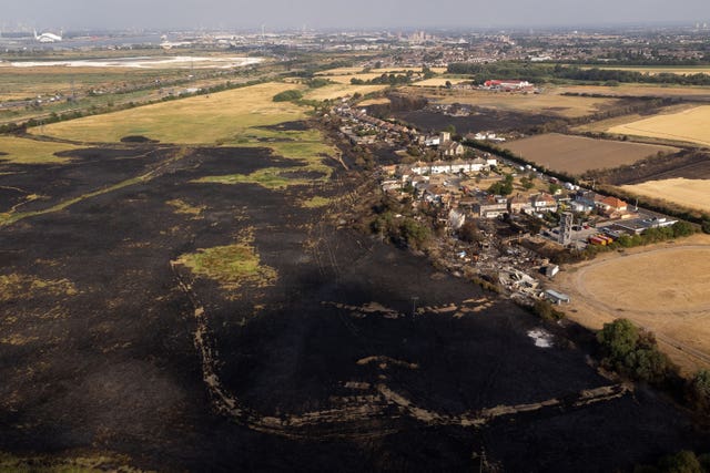 Aerial view of scorched fields and ruined buildings after a blaze in Wennington, east London in July 2022