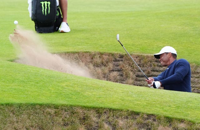 Tiger Woods blasts out of a bunker