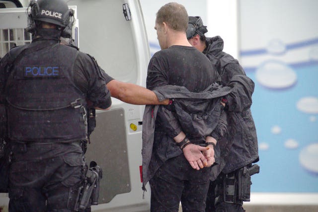 A man is led away after being arrested by police (Ben Birchall/PA)