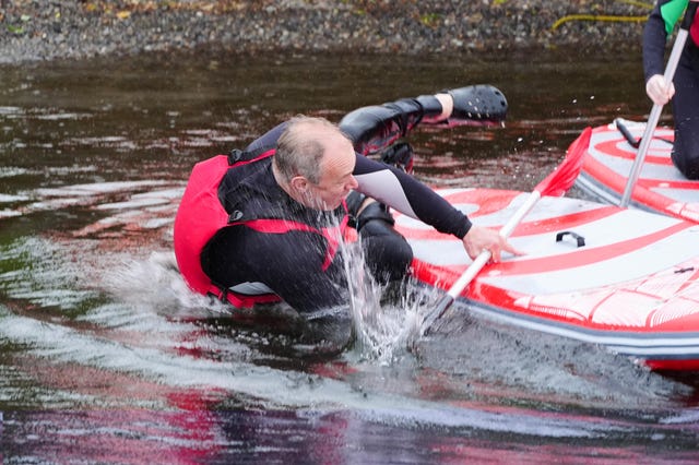 Liberal Democrat Leader Sir Ed Davey falls into the water while paddleboarding on Lake Windermere