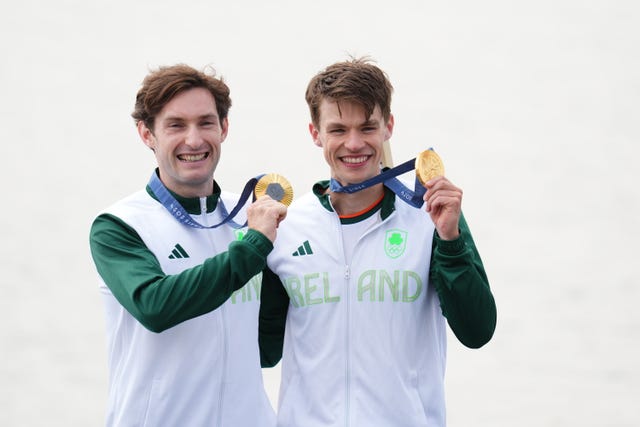 Fintan McCarthy and Paul O’Donovan hold up their gold medals