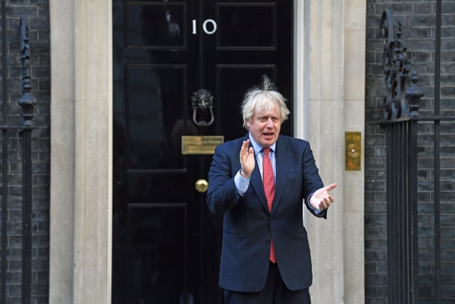 Prime Minister Boris Johnson applauds at 10 Downing Street