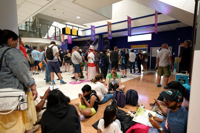 Spectators are held outside during a delay to inspect a health and safety issue