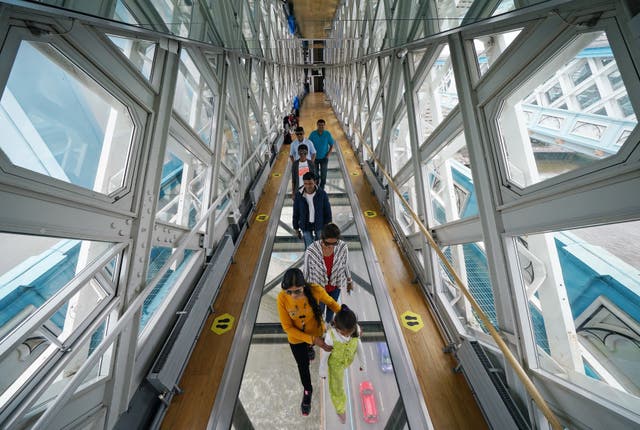 Visitors take in the view through the Glass Floor on the high-level walkway at Tower Bridge in London (Yui Mok/PA)