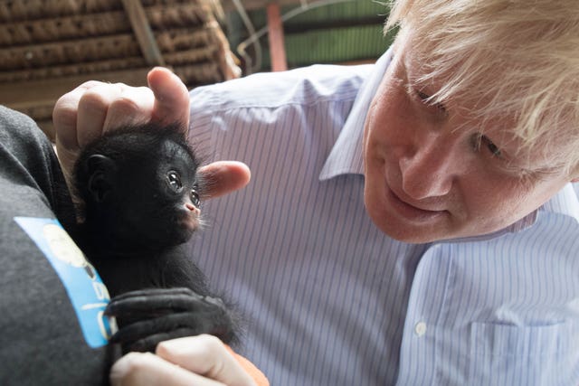Boris Johnson is shown a baby black spider monkey (Stefan Rousseau/PA)
