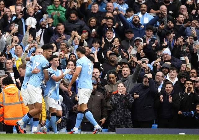 Phil Foden, centre, celebrates with team-mates after scoring Manchester City’s first goal against Manchester United