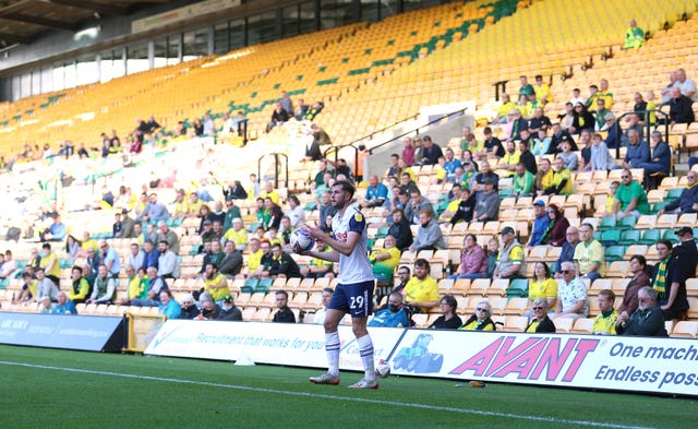 Preston North End’s Tom Barkhuizen takes a throw in as fans watch at Carrow Road