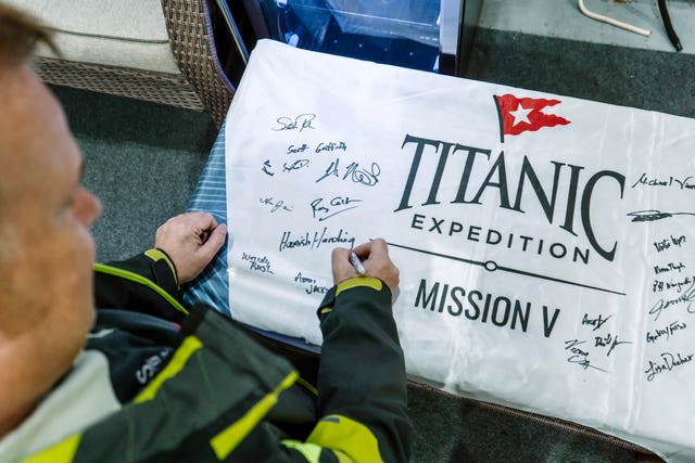 Hamish Harding signing a Titanic Expedition sign