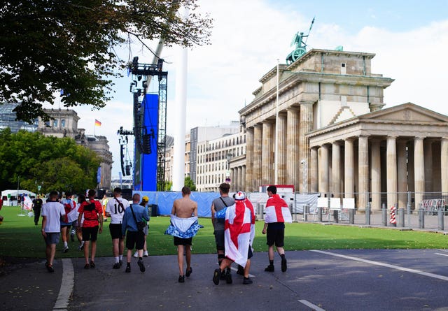 A group of England fans walk towards the Brandenburg Gate in Berlin