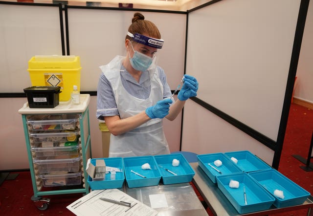 A nurse in PPE prepares Covid-19 vaccines.