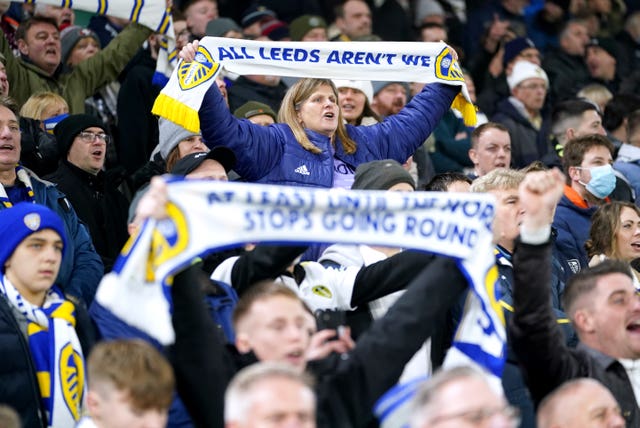 Leeds fans hold up scarves reading ''All Leeds aren''t we'' and ''At least until the world stops going round''