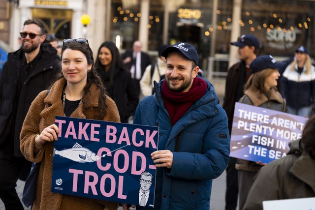 Protesters holding placards reading 'Take back cod-trol'