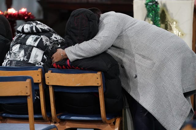 People hug during a vigil at St Mary Magdalene church in Woolwich