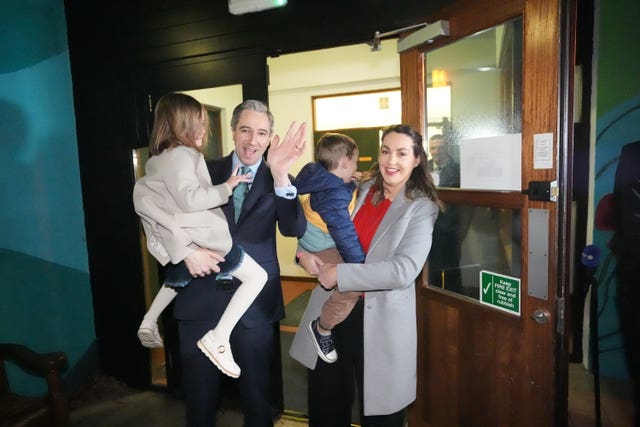 Simon Harris and his wife hold their two children outside a voting station