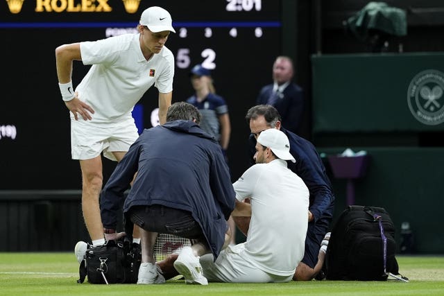 Jannik Sinner (left) checks on Grigor Dimitrov as he receives treatment for an injury 