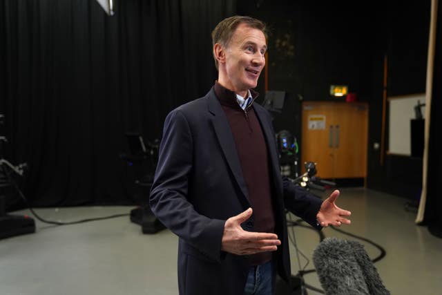 Chancellor Jeremy Hunt speaking in front of a microphone