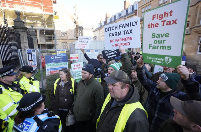 Police officers opposite farmers holding placards