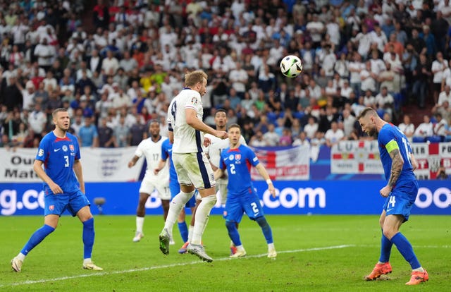 England’s Harry Kane leaps to head home a goal against Slovakia