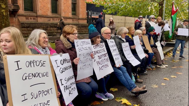 Protesters sitting and holding signs in Belfast
