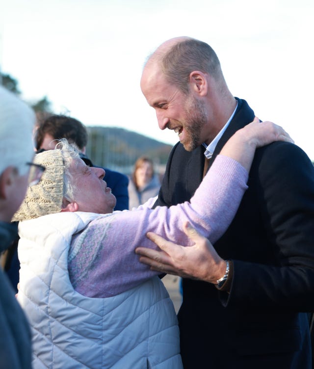 The Prince of Wales is hugged by a member of the public after a walk along Colwyn Bay beach in North Wales with members of the Marine Conservation Society’s Youth Ocean Network on November 25