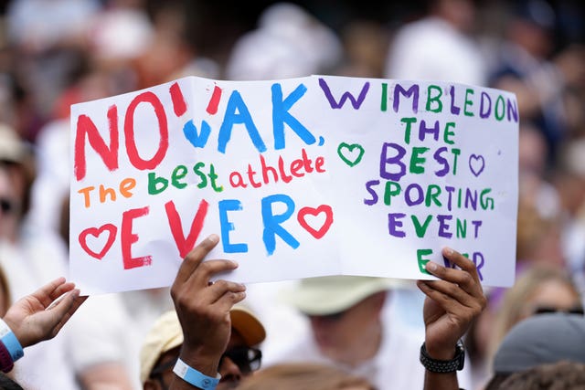 A fan holds up a Novak Djokovic banner