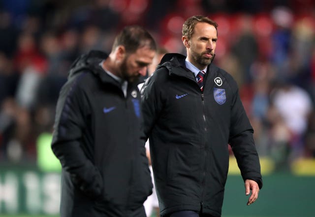 Southgate and his assistant Steve Holland walk off the pitch dejected after the match 