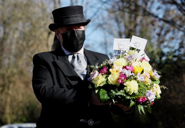 Funeral director Colette Sworn gathers a floral tribute as part of her preparations to oversee a funeral at Co-op Funeralcare in Watford, Hertfordshire