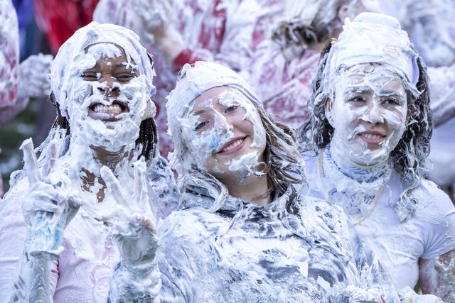 Three smiling student taking part in the traditional Raisin Monday foam fight