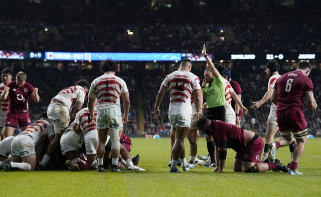 Players look on after Jamie George (obscured) scores a try