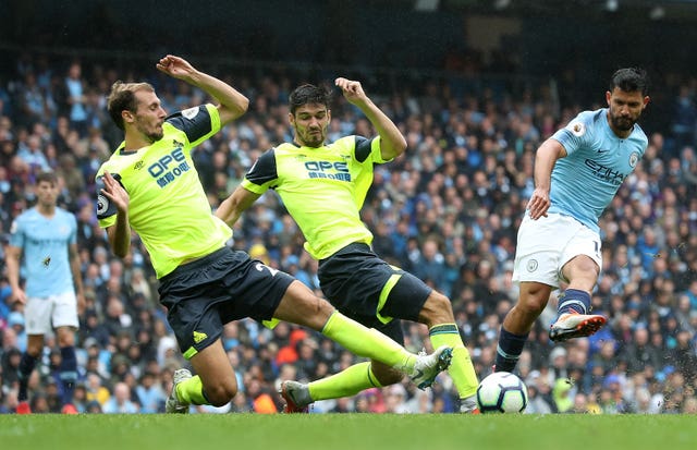 Sergio Aguero, right, takes a shot against Huddersfield