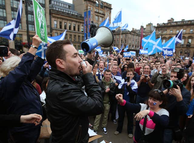 Martin Compson speaking into a loud speaker during a Yes rally