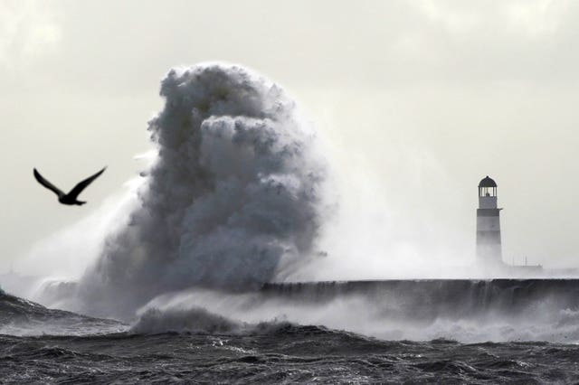 Waves crash against the lighthouse in Seaham Harbour, County Durham