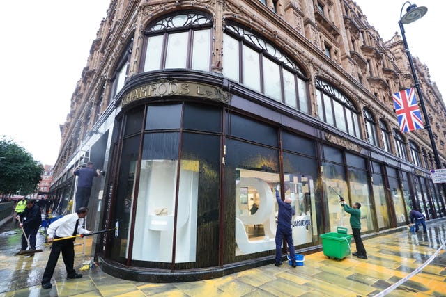 The front of Harrods department store in Knightbridge, London, is cleaned after activists from Just Stop Oil sprayed an orange substance on its windows