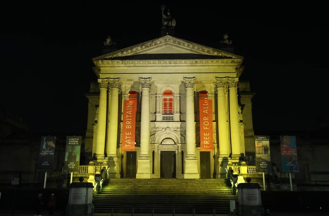 The Tate Britain in London is illuminated yellow during the National Day of Reflection, on the anniversary of the first national lockdown