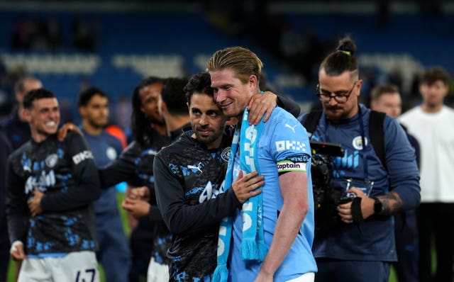 Kevin De Bruyne is embraced by Bernardo Silva, left, after his farewell game at the Etihad Stadium