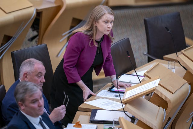 Shirley-Anne Somerville standing while speaking in Holyrood