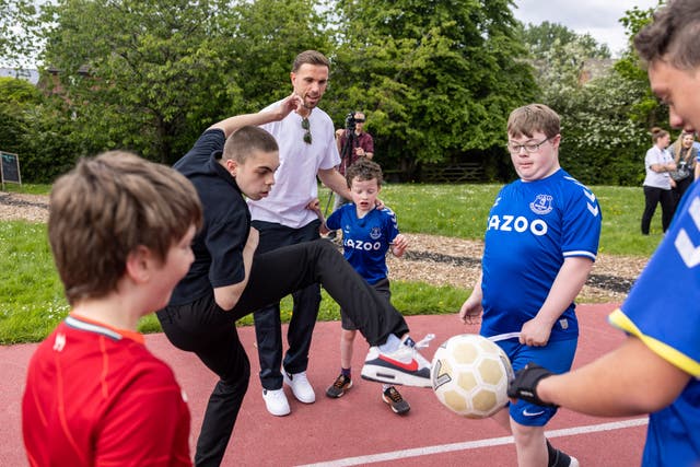 Jordan Henderson plays with school children