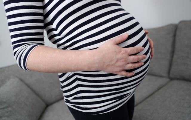 A pregnant woman holding her stomach