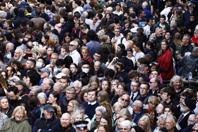 Members of the public gather near Mercat Cross to watch the procession 